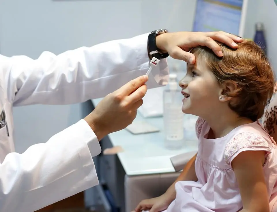 Child having an eye exam with eye chart, highlighting the importance of annual check-ups after the holidays.